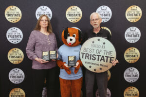 Marsh Run Kennels owners holding Best of the Tri-State awards with mascot, voted #1 dog boarding facility